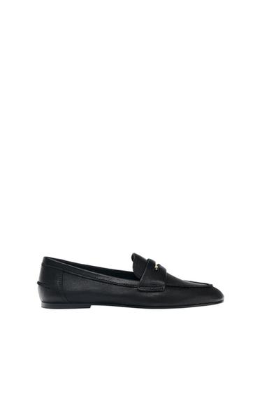 Black loafer with a strap across the vamp and prominent stitching, shown in profile against a white background.