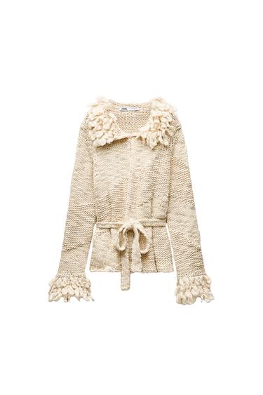 Front view of beige cardigan with wool detailing on collar and sleeves, belt tied at waist.