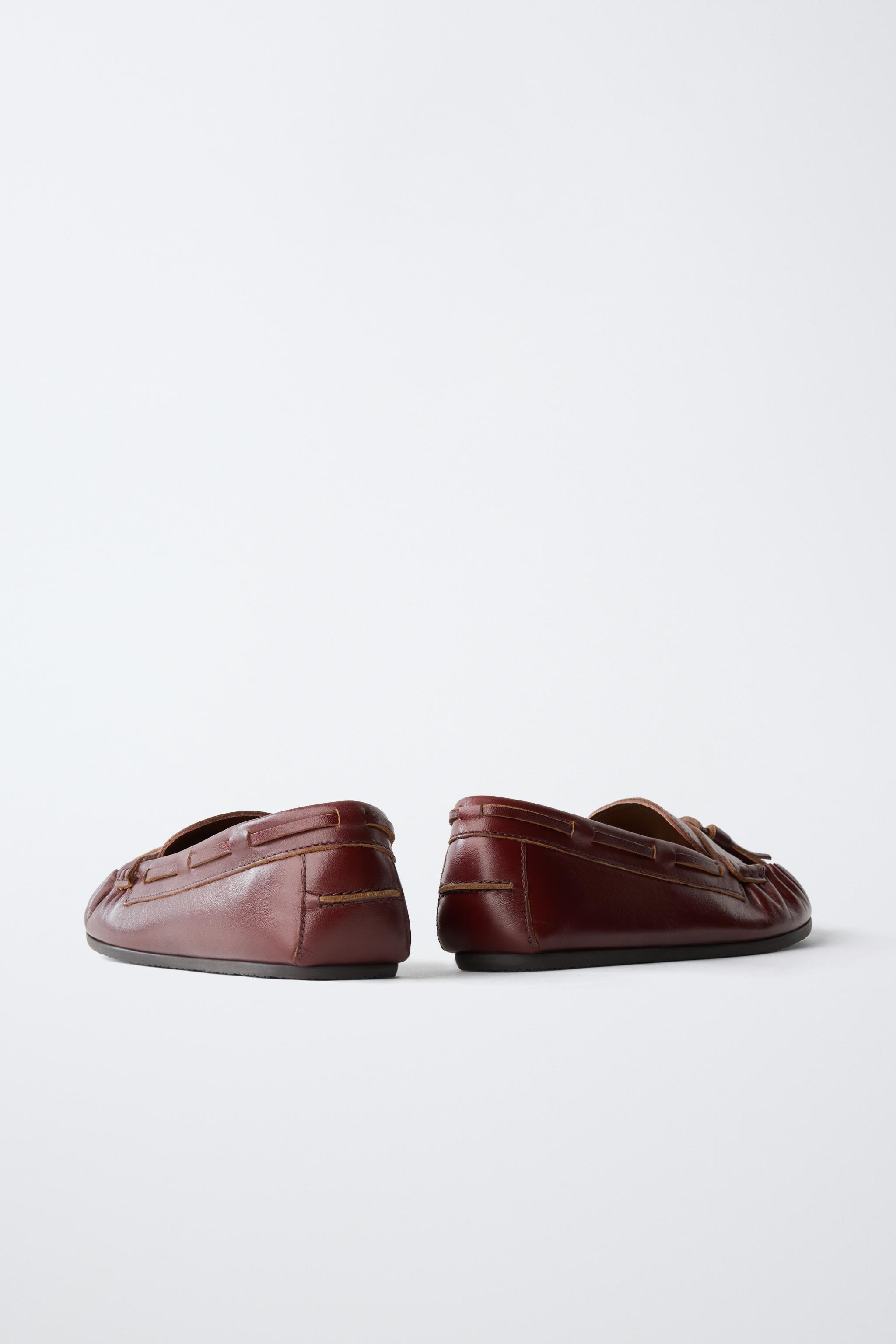 MOCASSINS EN CUIR À POMPONS