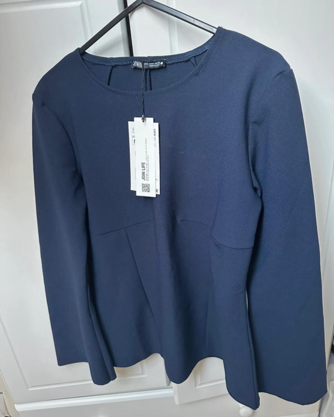 Navy blue long-sleeved blouse hanging on a black hanger, with visible label reading "JOIN LIFE", against a white wardrobe background.