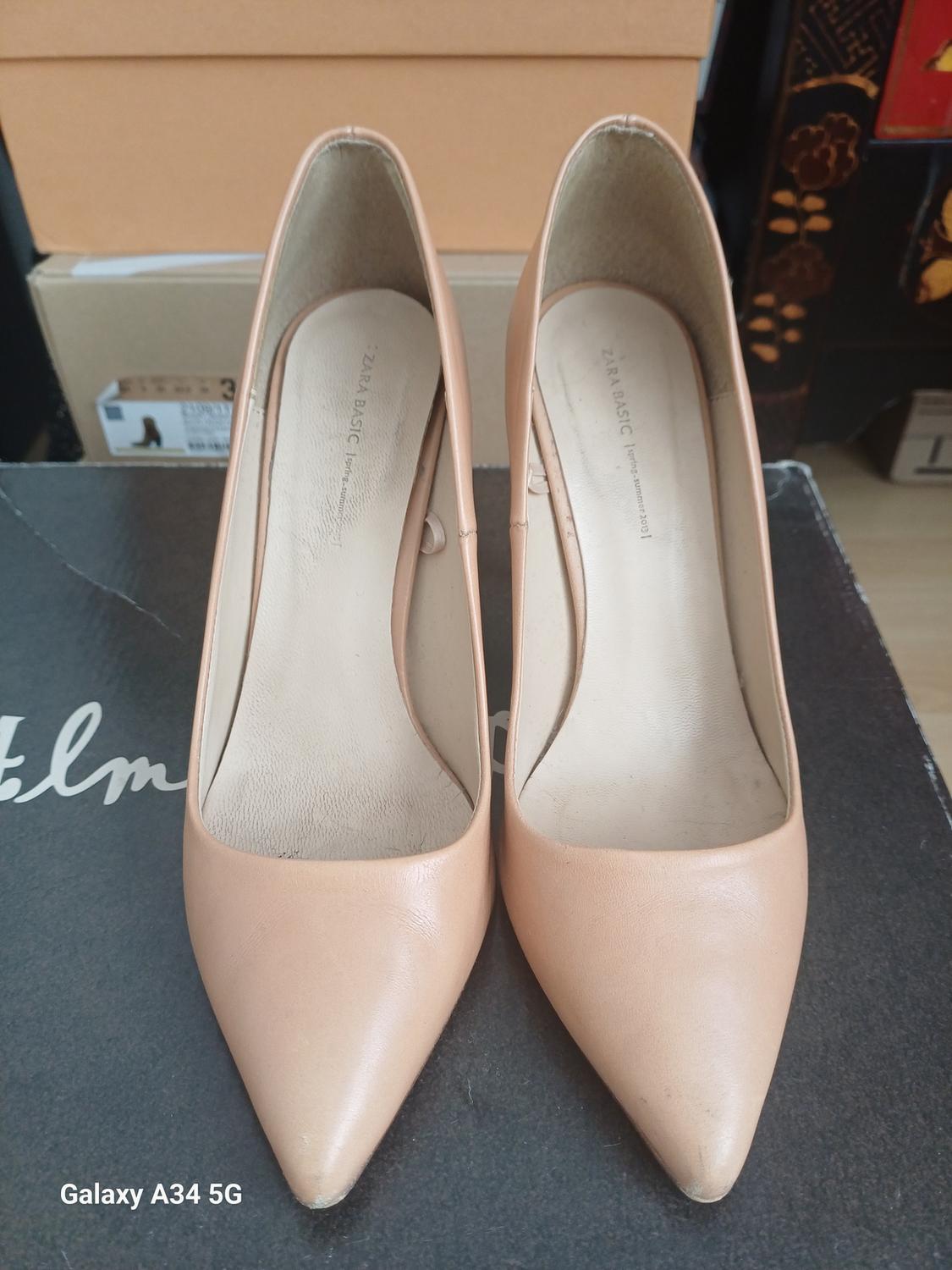 Beige stiletto heels with a pointed toe, top view.