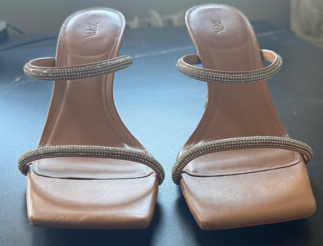 Front view of brown sandals with straps decorated with rhinestones