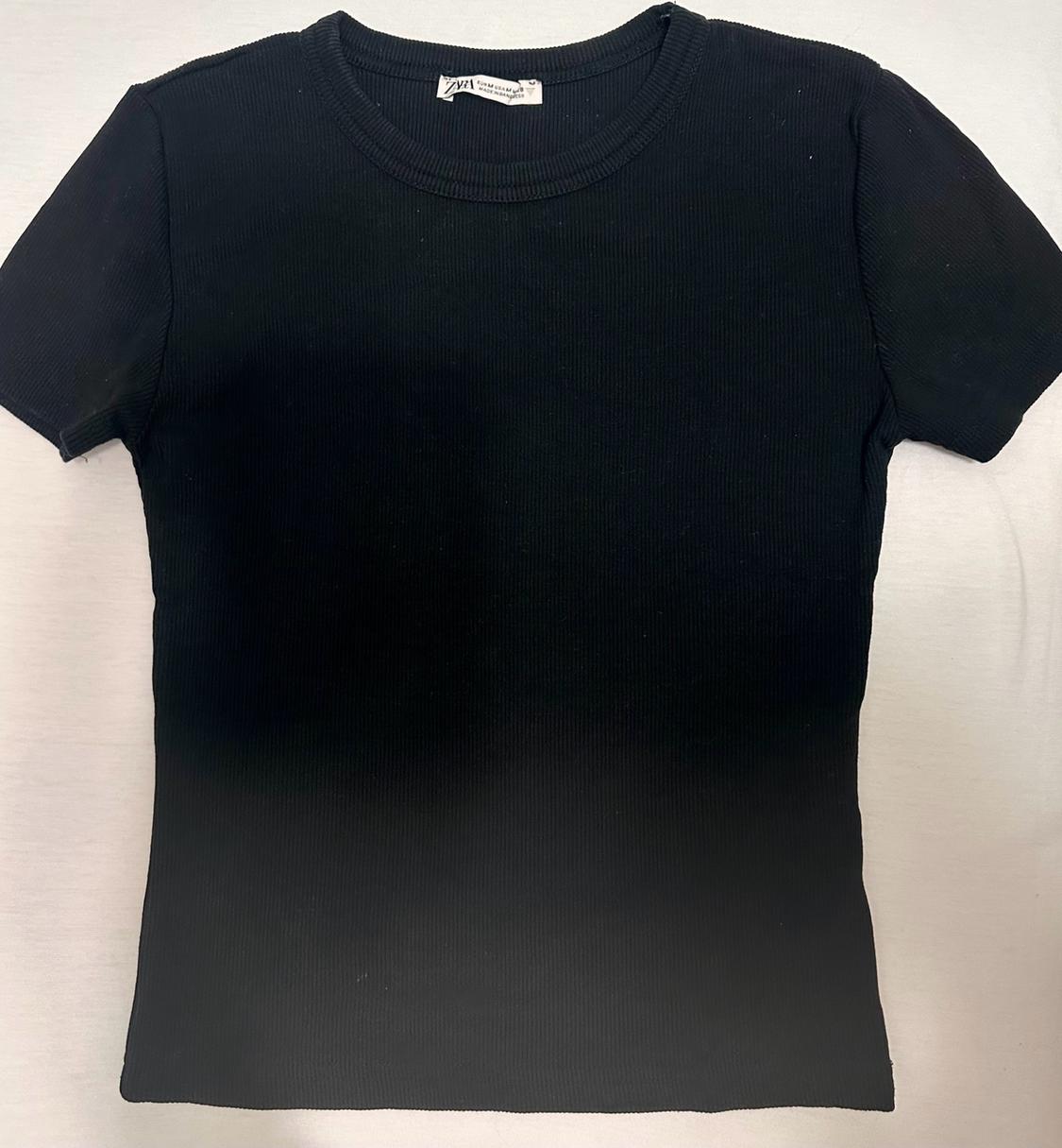 Basic black short-sleeved T-shirt with a ribbed crew neck on a light background. The label reads ZARA.
