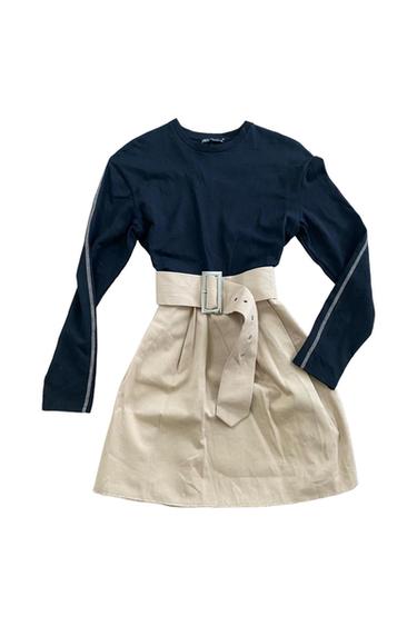 Dress with black long-sleeved top and beige skirt, wide belt with silver buckle.