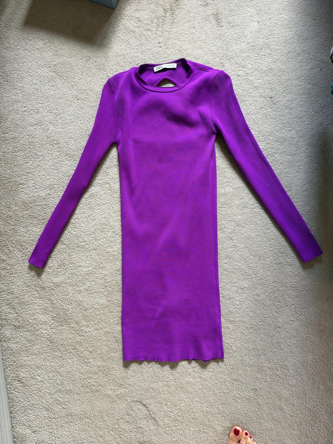 Purple ribbed-knit, long-sleeved dress with a ZARA label, laid out on a light grey carpet.