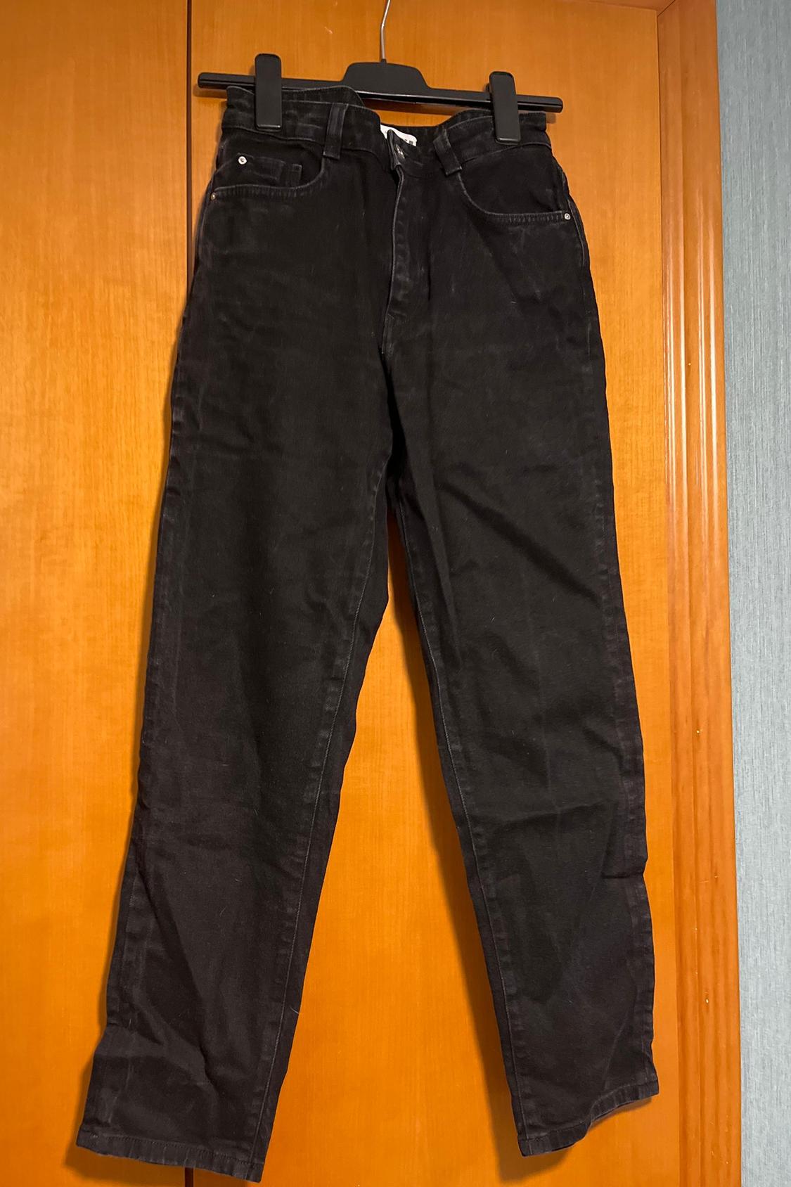 Front view of black trousers with front pockets and belt loops.