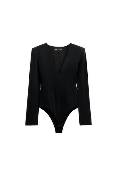 Long-sleeved black bodysuit with a deep V-neck, on a white background. Label visible on the neck.