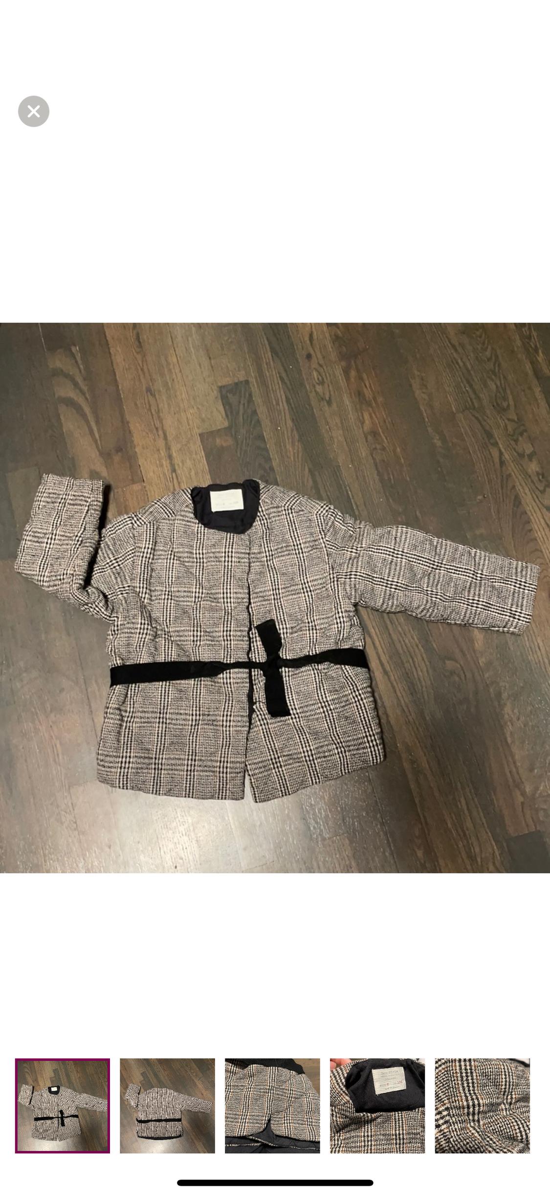 Plaid puffer jacket on a wooden floor, with a black belt and dark collar. View of several thumbnail images below.