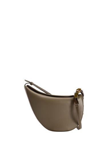 Side view of a brown bag with an adjustable strap and decorative buckle.