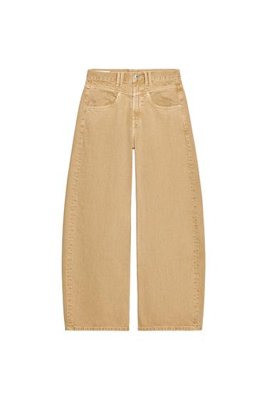 Front view of low-rise baggy ochre jeans with front and back patch pockets, front zip and button closure.