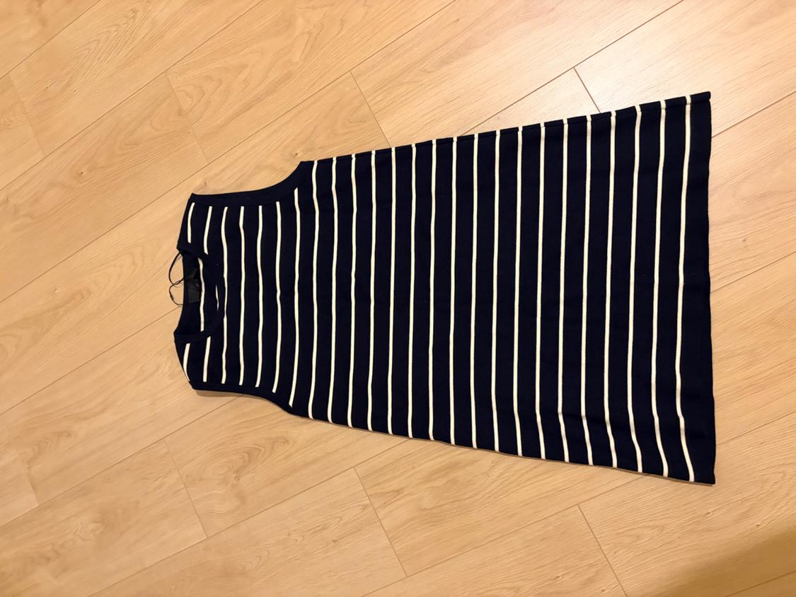 Navy and white horizontal striped sleeveless casual dress, laid out on a light wood floor with a relaxed vibe.