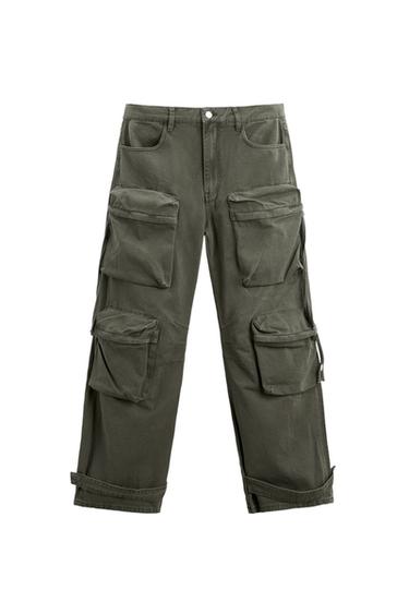 Front view of green cargo trousers with large side pockets and rolled-up hem.