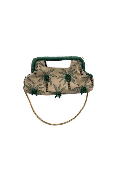 Beige bag with a green palm tree print and a gold handle. Dark green details on the top edge and sides.