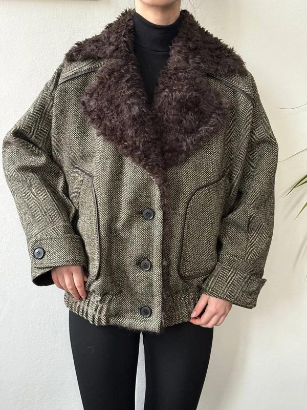Model wearing a brown wool jacket with a faux fur lapel and large buttons, against a white background. She is wearing a black jumper and leggings.