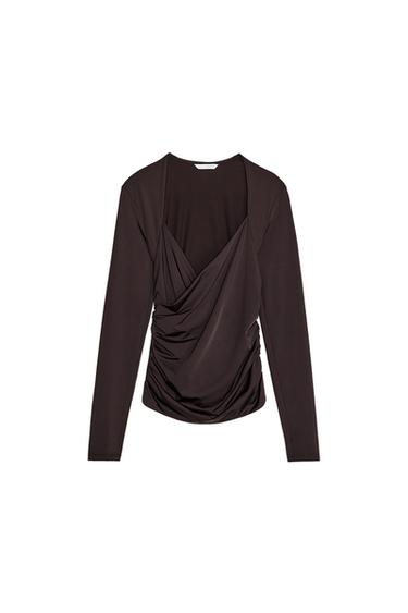 Front view of a brown blouse with draping at the front and long sleeves.