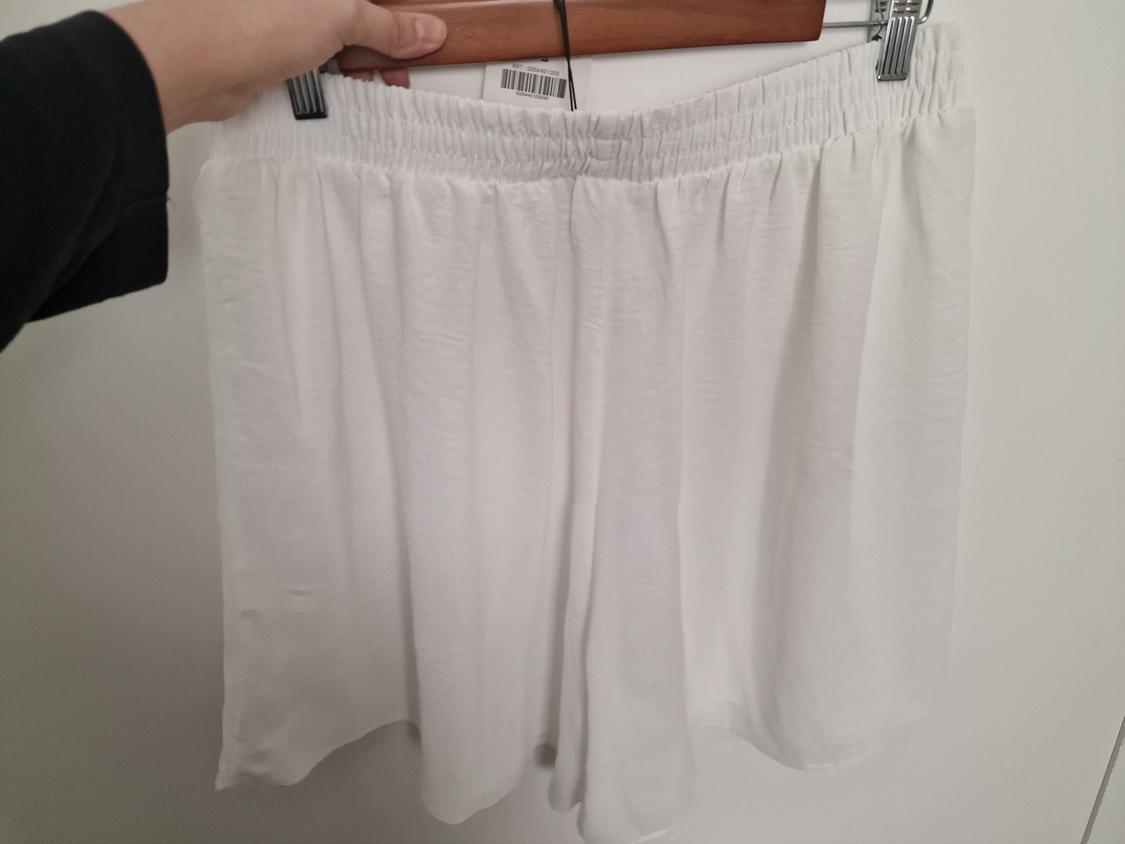 Front view of white shorts with an elasticated waistband.