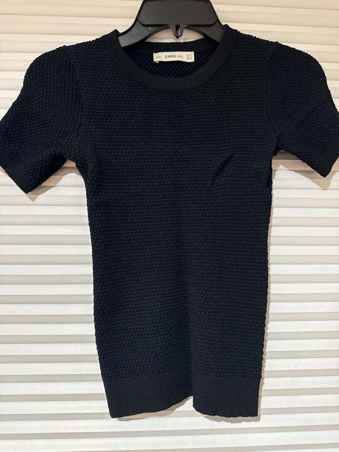 Front view of a short-sleeved black textured sweater.