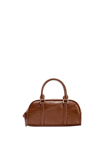 Brown leather handbag with short handles and gold details on a white background. Elegant and minimalist design.