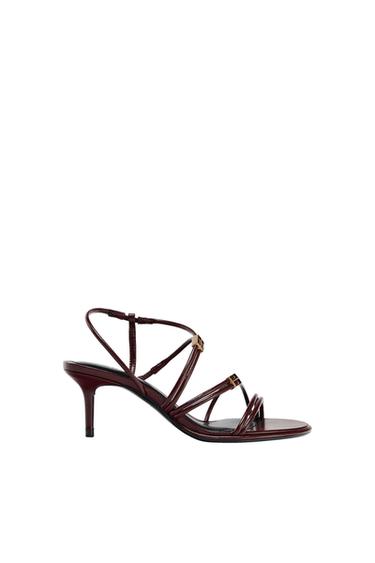 Burgundy stiletto-heel sandal with multiple criss-cross straps against a white background.