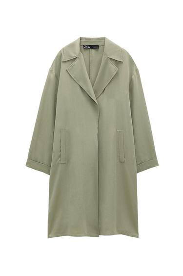 Light green long coat with lapel collar, long sleeves and front pockets on a white background. Inner label with ZARA text.