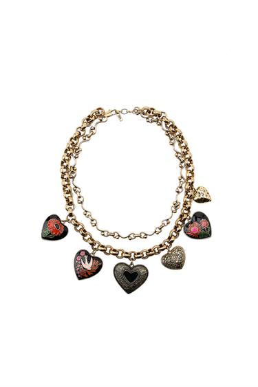 Front view of two gold necklaces with enamelled and engraved heart pendants, lobster clasp.