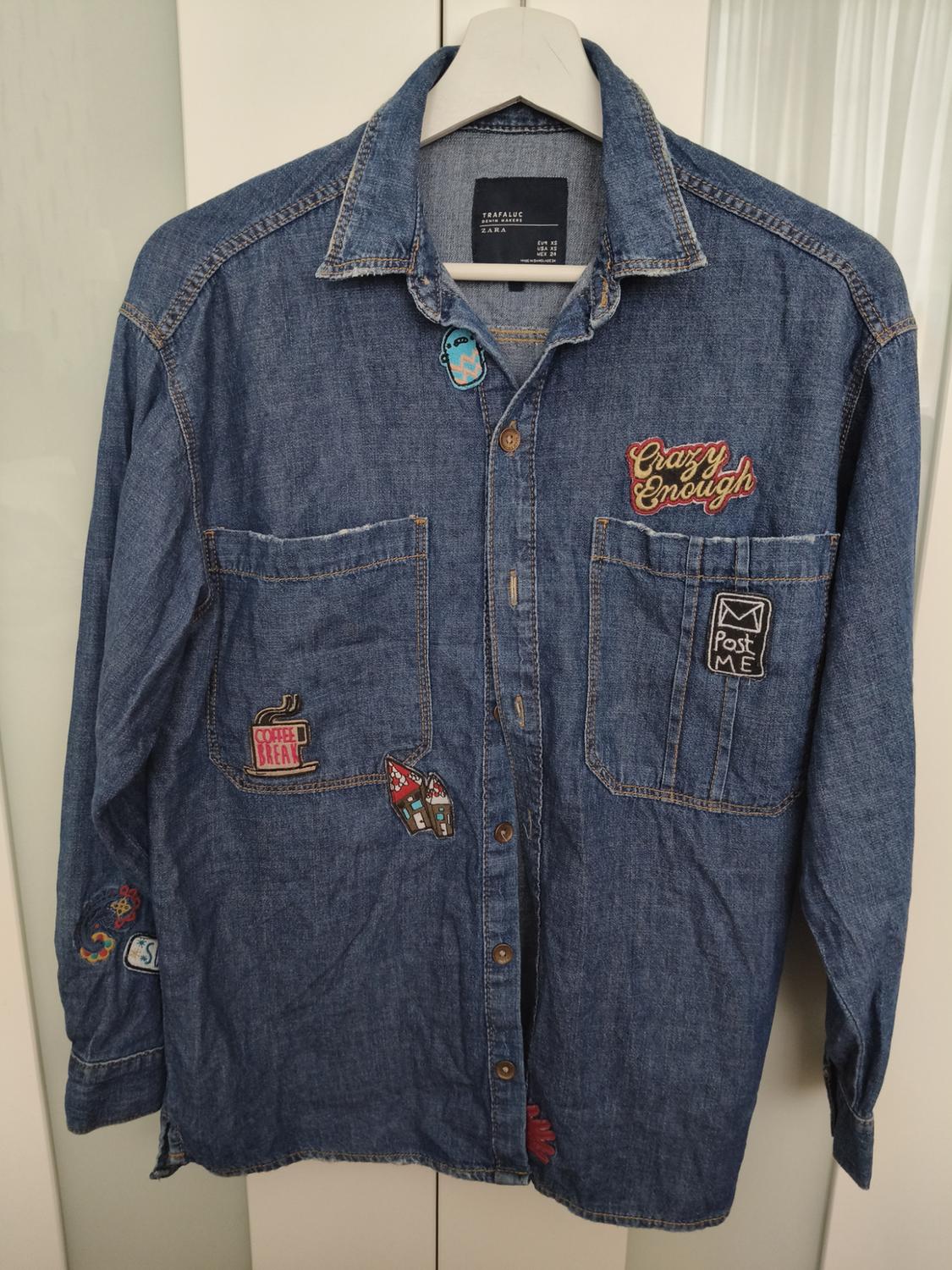 Front view of denim shirt with patches and text 'Crazy Enough', 'Post Me', 'Coffee Break'. Front pockets.
