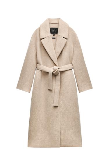 Front view of a beige coat with belt and wide lapels.