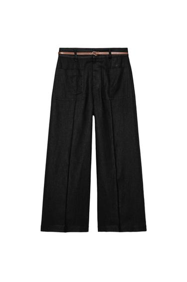 Rear view of black trousers with brown belt and back pockets.