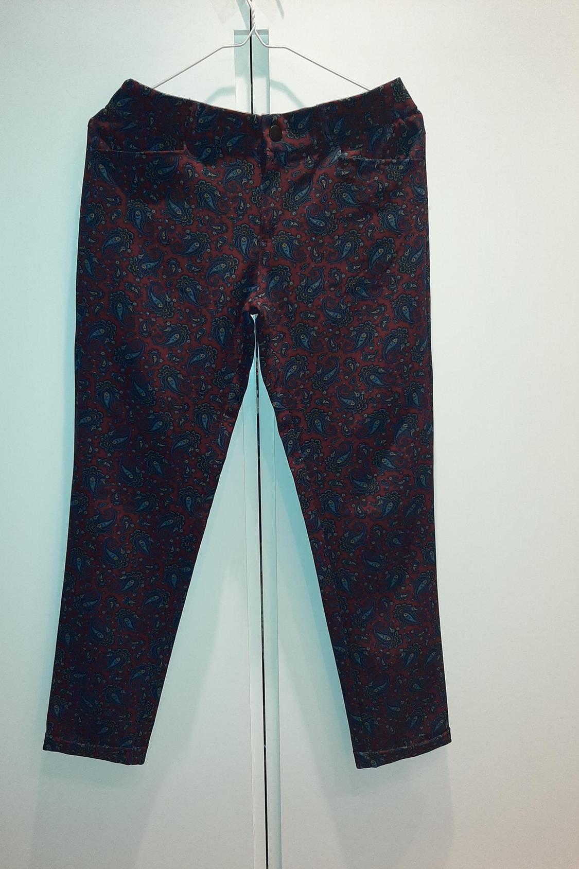 Front view of dark-toned paisley print trousers.