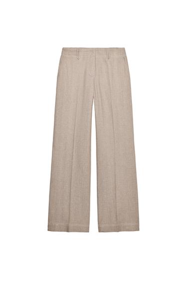 Front view of beige pants with side pockets and belt loops.