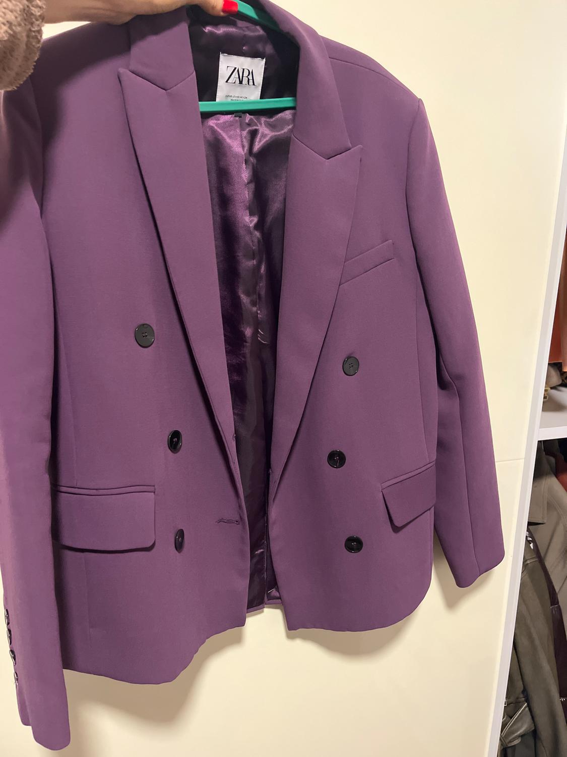 Purple double-breasted jacket hanging on a green hanger. Visible label with the text "ZARA".