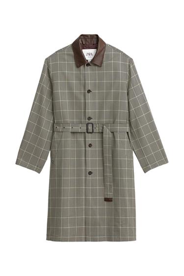 Front view of black and green checked trench coat with brown collar, front button fastening, belt, and side pockets.