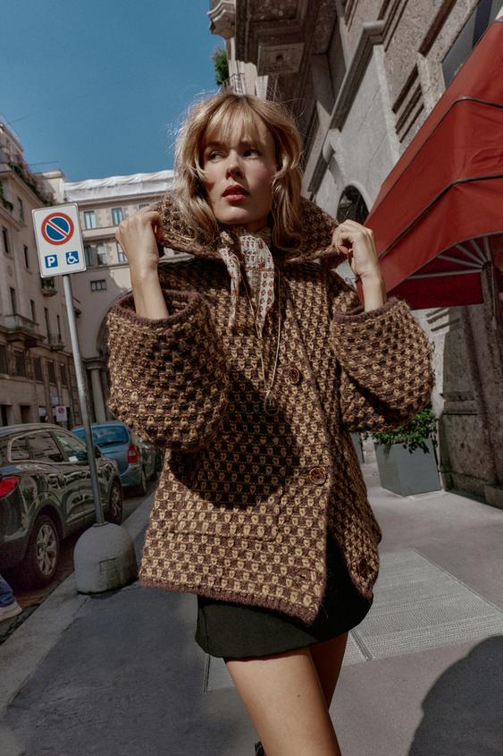 Pleten souprava kabtu v hndo-norkov barv s klopou a dlouhmi rukvy, pednmi knoflky a geometrickm vzorem.