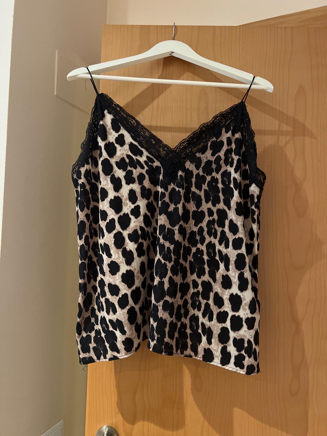 Front view of a camisole top with a leopard print and black lace at the neckline.