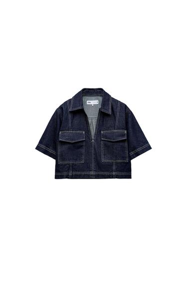Dark blue short-sleeved denim shirt with white stitching, collar and front pockets on a white background. Text ZARA.