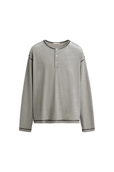 Long-sleeve shirt with horizontal black and white stripes. Design with a buttoned henley neckline on a white background.
