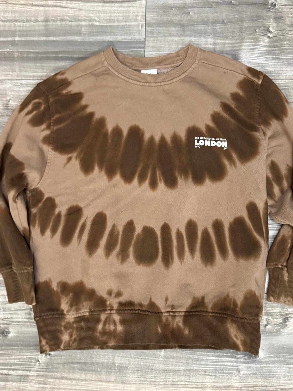 Brown crew-neck sweatshirt with a tie-dye effect on wood. Text: 333 OXFORD ST. MAYFAIR. LONDON W1C 2NY.