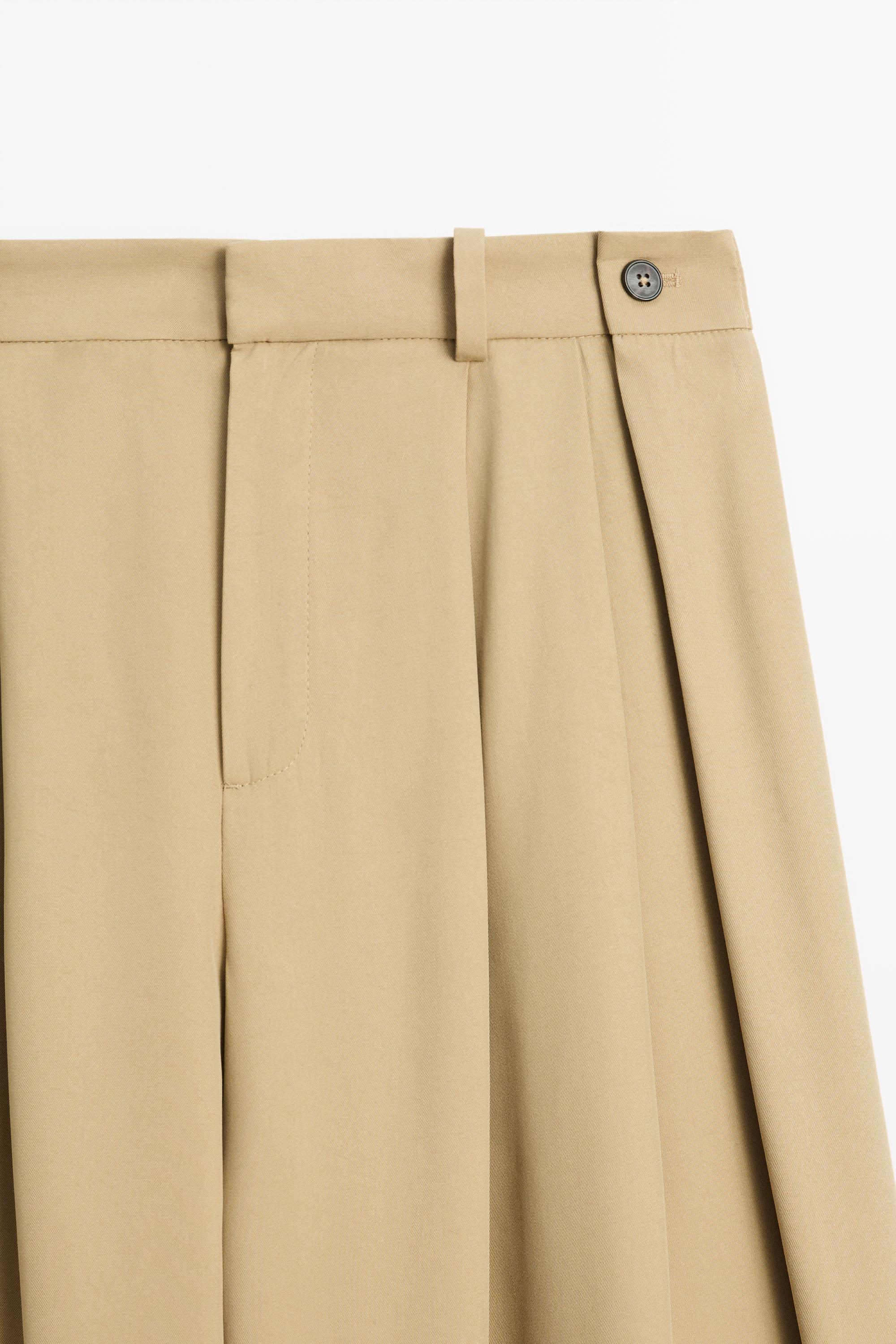 Flowing pleated pants with button detail
