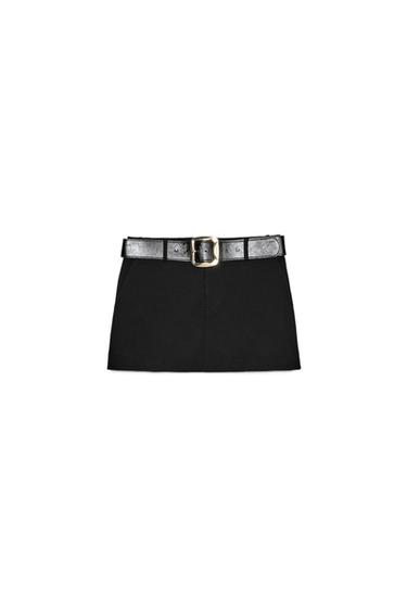 Front view of short black culottes with a wide belt and front pockets. Front zip fastening.