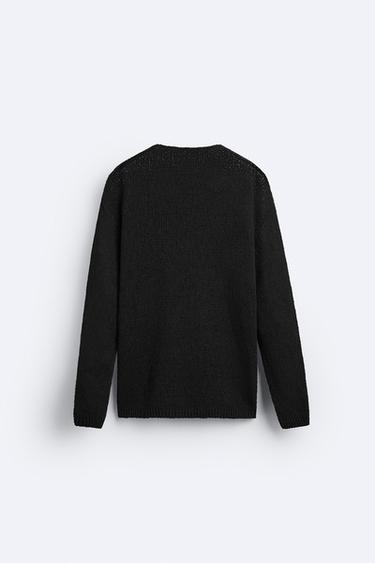 El jersey negro de Zara barato, básico y atemporal que las mujeres de 50  llevarán con falda plisada en looks elegantes