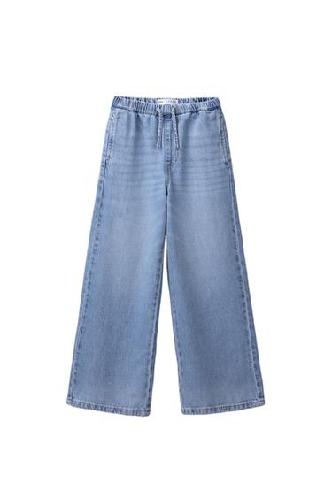 Front view of wide leg, light blue denim jeans with elasticated waist and side pockets.