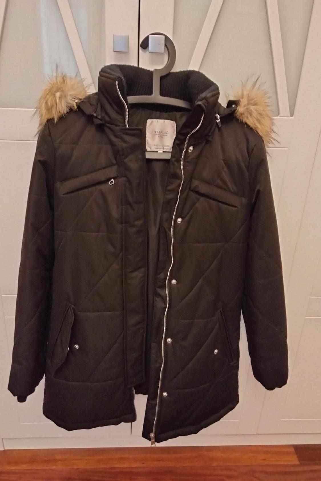 Front view of a brown coat with a faux fur hood and front flap pockets.