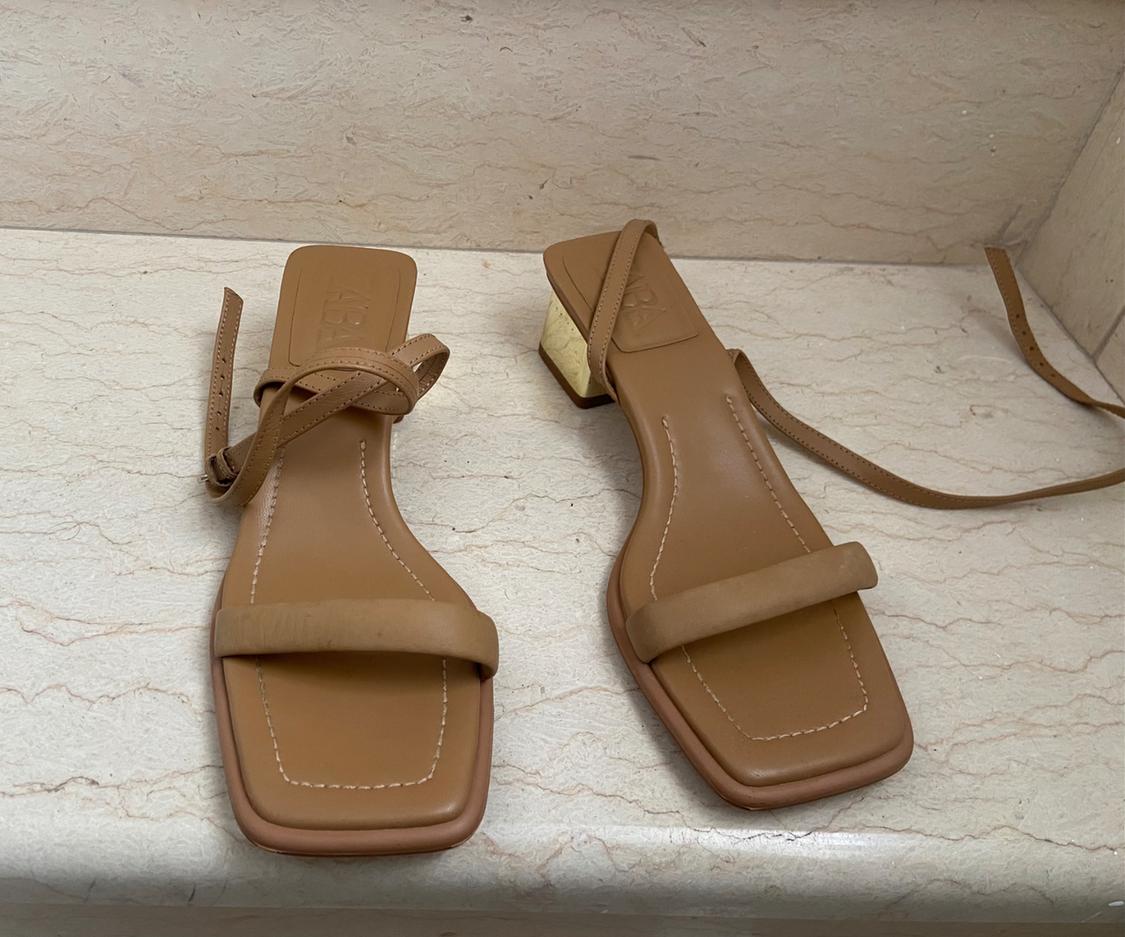 Front view of brown sandals with a block heel and thin straps.