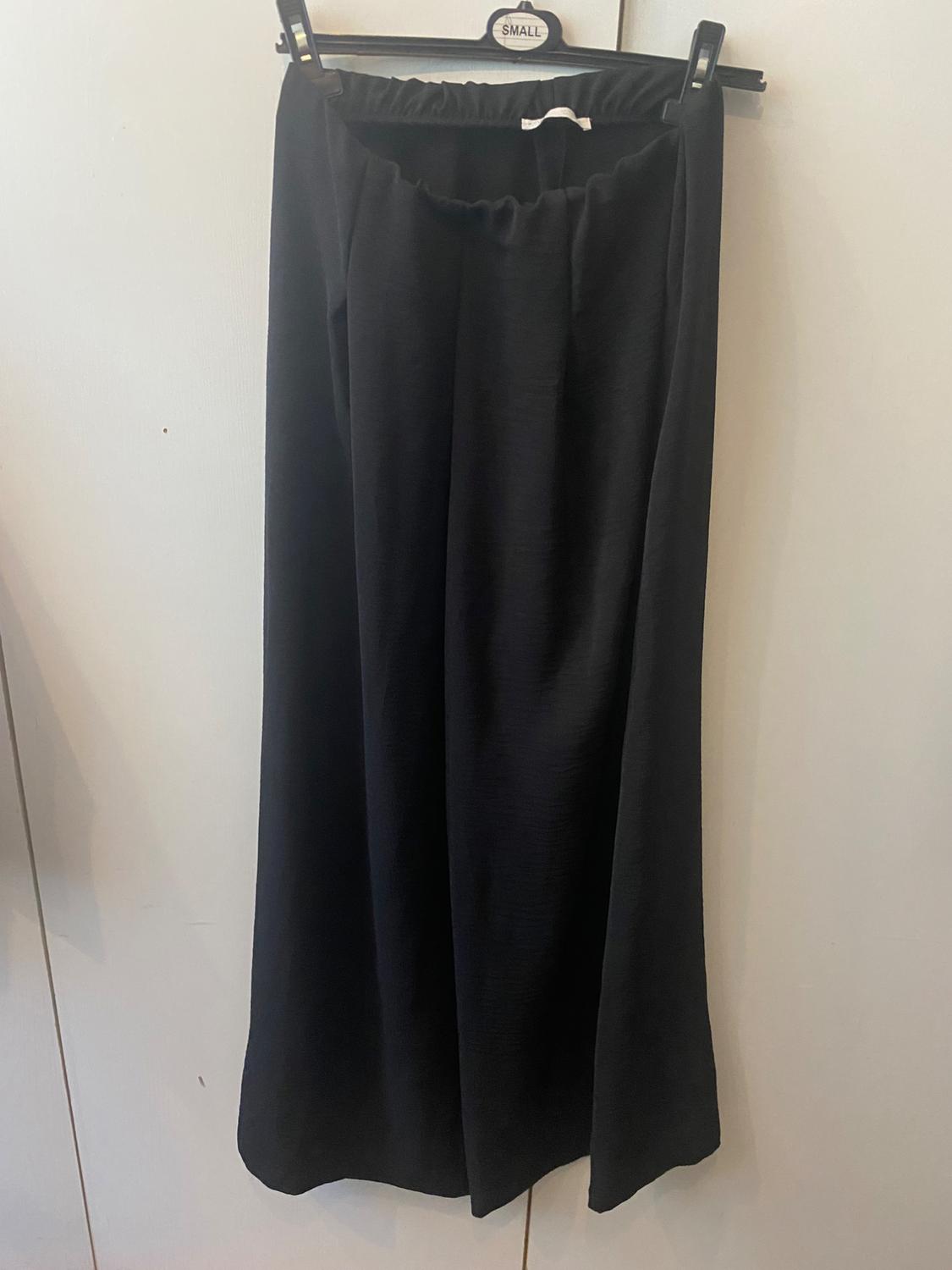 Black, lightweight fabric trousers hanging on a hanger with a "SMALL" tag, against a white background.