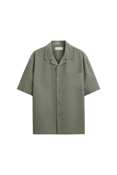 Olive green, short-sleeved shirt with an open collar and a chest pocket. Front buttons and a visible label inside the collar.
