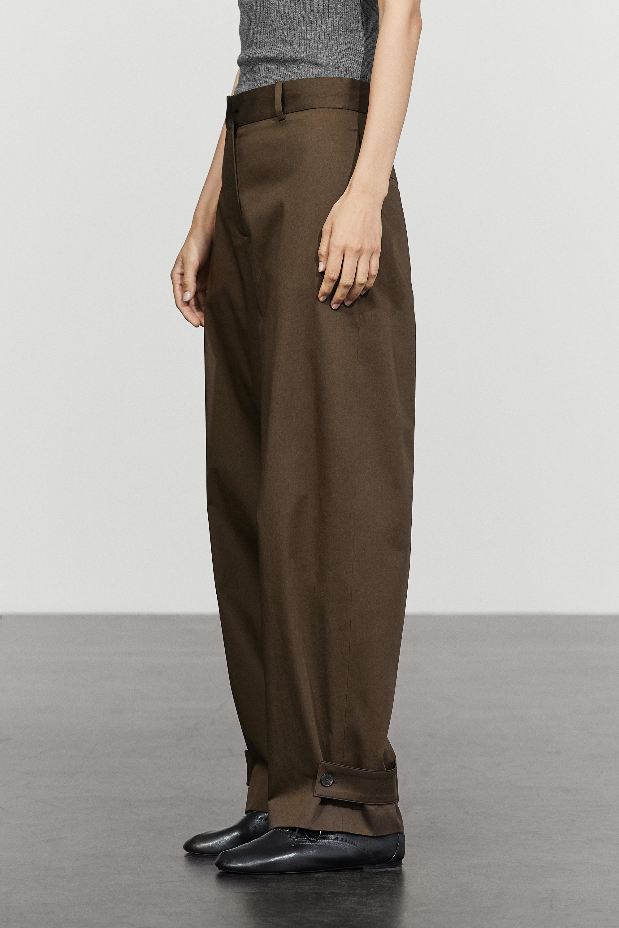 Pants with button-tab hem detail — Black gold