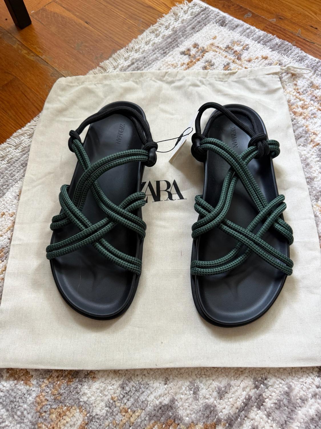Black sandals with green rope straps on a fabric bag with the text ZARA. The insoles read ZARA MAN.