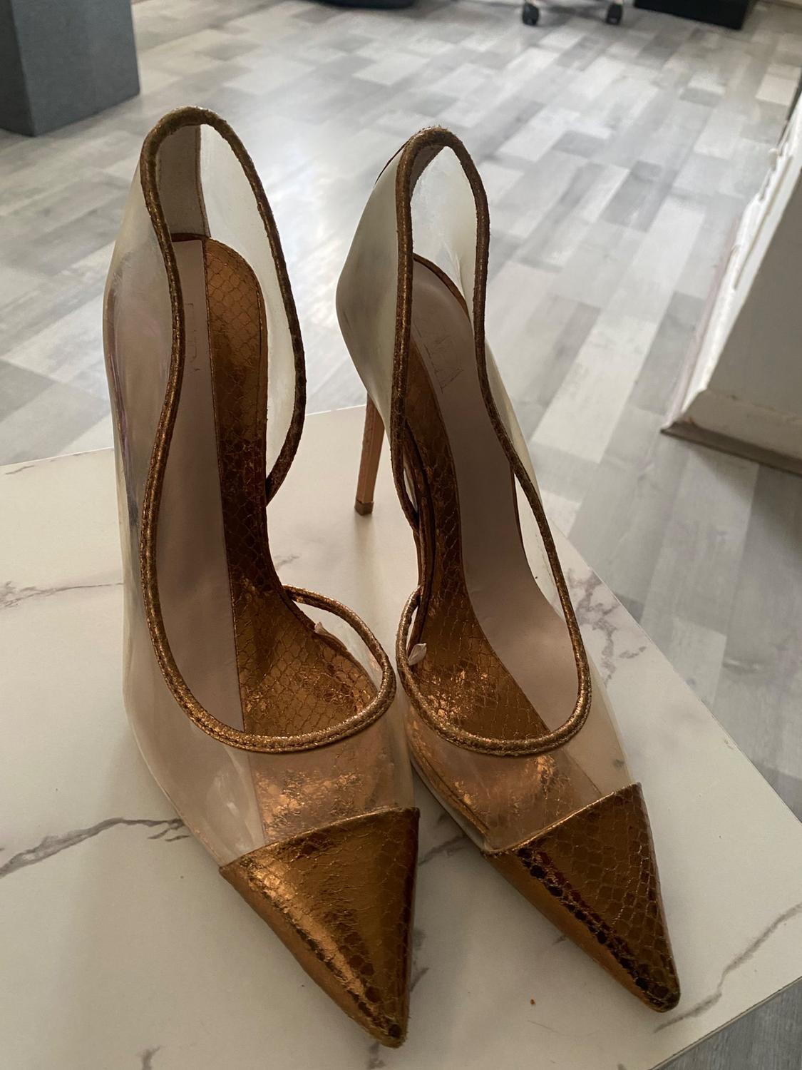High heels with gold toe and clear sides.