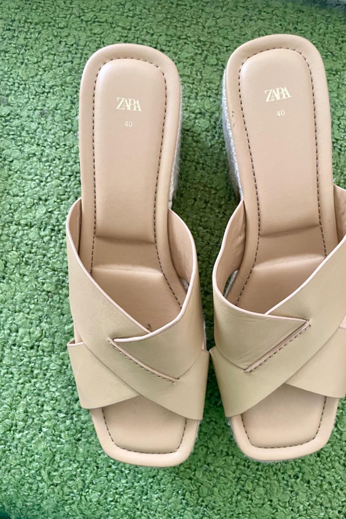 Front view of beige sandals with crossed straps and a footbed with the text 'ZAPA 40'.