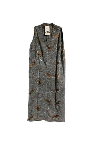 Silver sleeveless dress with gold sequins, hanging on a hanger with a visible label that says "ZARA".